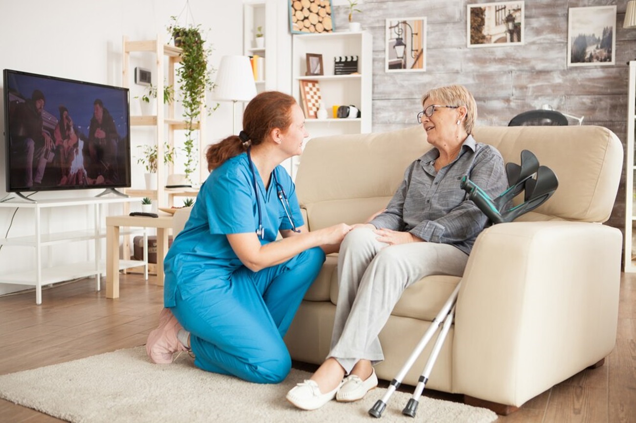 young-female-nurse-wearing-blue-uniform-talking-with-senior-woman-nursing-home_482257-22514